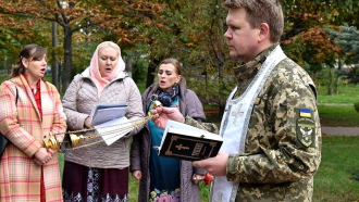 Isä Sergiy Berezhnoy toimittamassa sotilasasussa