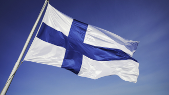 Suomen lippu liehuu auringossa