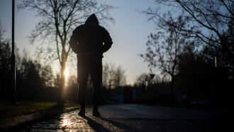 Yksinäinen mies kävelee aamuauringossa