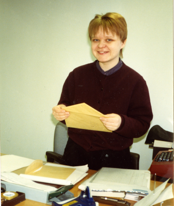 Museoapulainen Marke Penttinen liimaamassa postimerkkejä museossa 1990-luvulla