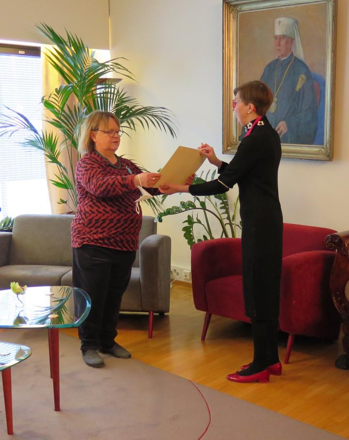 Suomen ortodoksisen kirkkomuseo RIISAn johtaja Teresa Töntsi luovuttaa Marke Penttiselle arkkipiispa Leon myöntämän siunauskirjan
