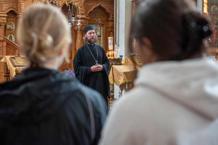 Valamon luostarin igumeni arkkimandriitta Mikael opastaa nuoria Valamon kirkossa