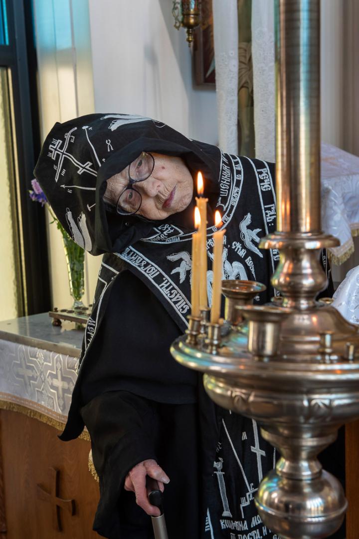 Lintulan luostarin skeemanunna Melania sytyttää tuohusta kirkossa