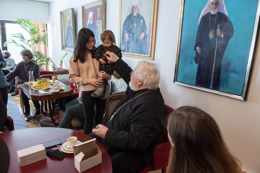 Ukrainasta paenneet äiti ja lapsi juttelemassa arkkipiispa Leolle
