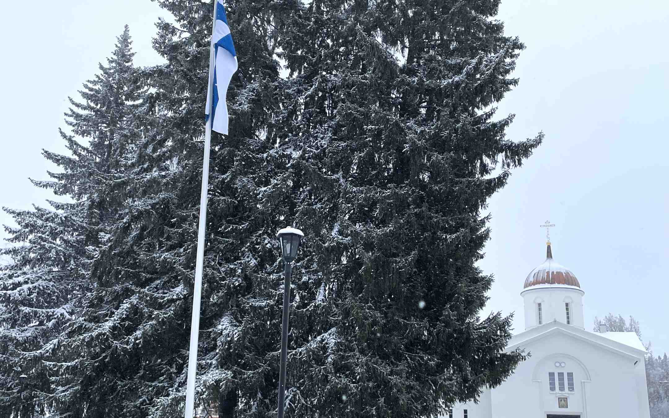 Valamon luostarin kirkon edustalla liehuu Suomen lippu