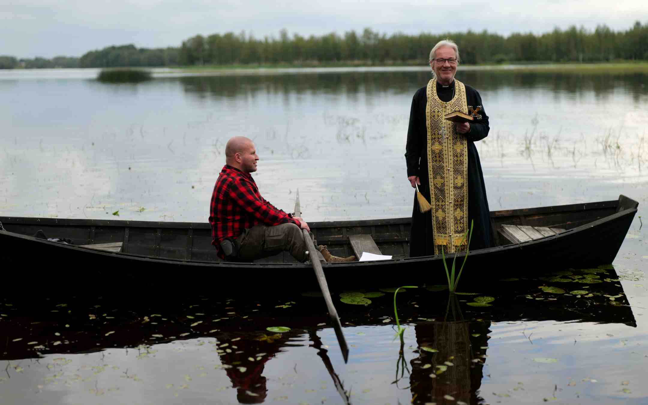 Kimmo Harju tarttui airoihin, kun isä Pekka Helakallio toimitti vedenpyhityksen Alajärven rannalla
