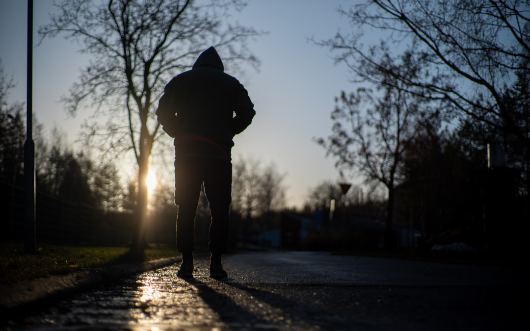 Yksinäinen mies kävelee aamuauringossa