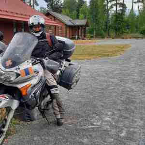 Kanttori Minna Jokinen poseeraa moottoripyöränsä kanssa Kaunisniemen leirikeskuksessa