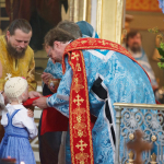 Tyttö osallistuu ehtoolliselle yhdessä äitinsä kanssa Uspenskin katedraalissa