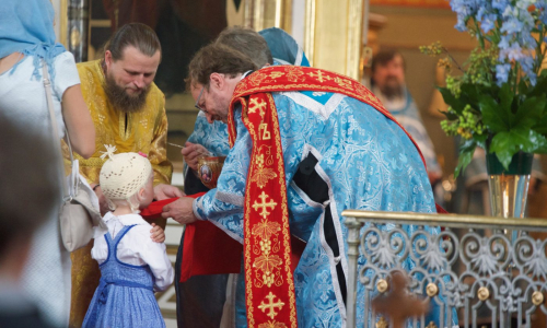 Tyttö osallistuu ehtoolliselle yhdessä äitinsä kanssa Uspenskin katedraalissa