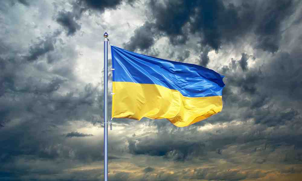 Ukrainan sinikeltainen lippu liehuu tuulessa taustallaan synkkiä myrskypilviä