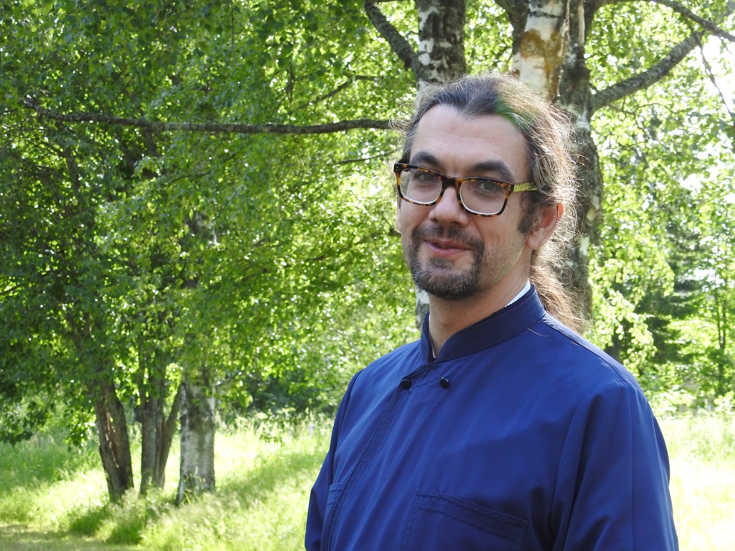 Ortodoksipappi Ioannis Lampropoulos seisoo kesällä ulkona