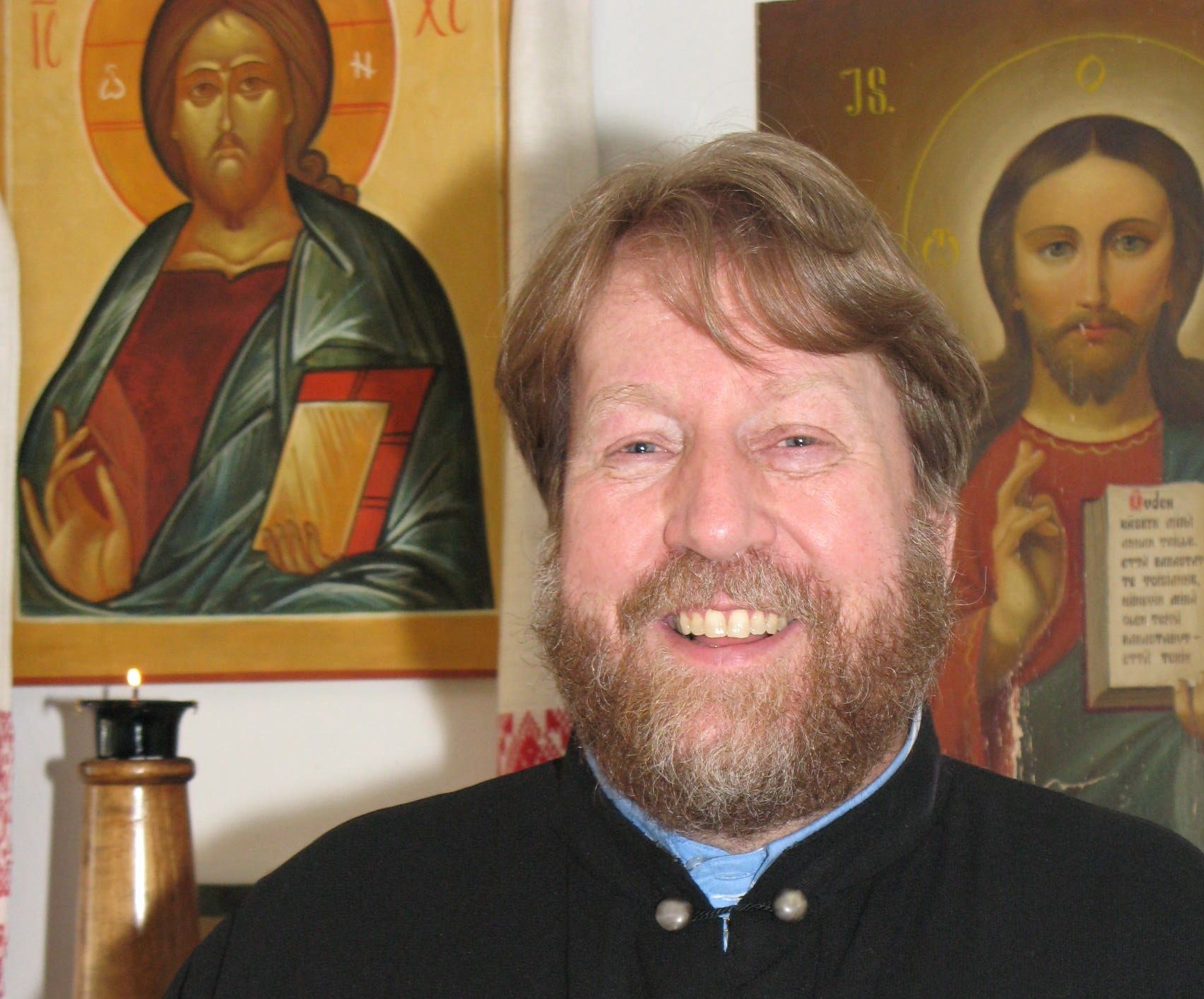 Isä Timo Mäkirinta Jyväskylän ortodoksisesta seurakunnasta lähikuvassa ikoneiden kanssa