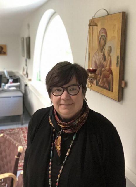 Valamon opiston rehtori Sirpa Koriala kuvattuna ty&ouml;huone taustallaan
