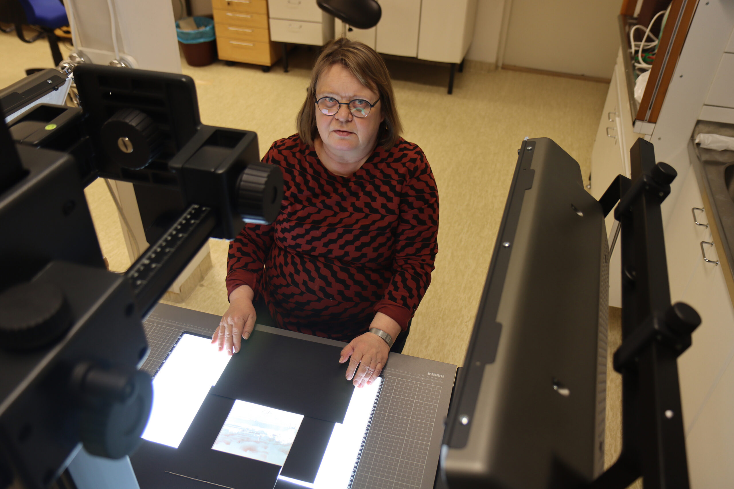 Marke Penttinen kuvaa arkkipiispa Hermanin lasinegatiiveja Suomen ortodoksisen kirkkomuseo Riisan tiloissa