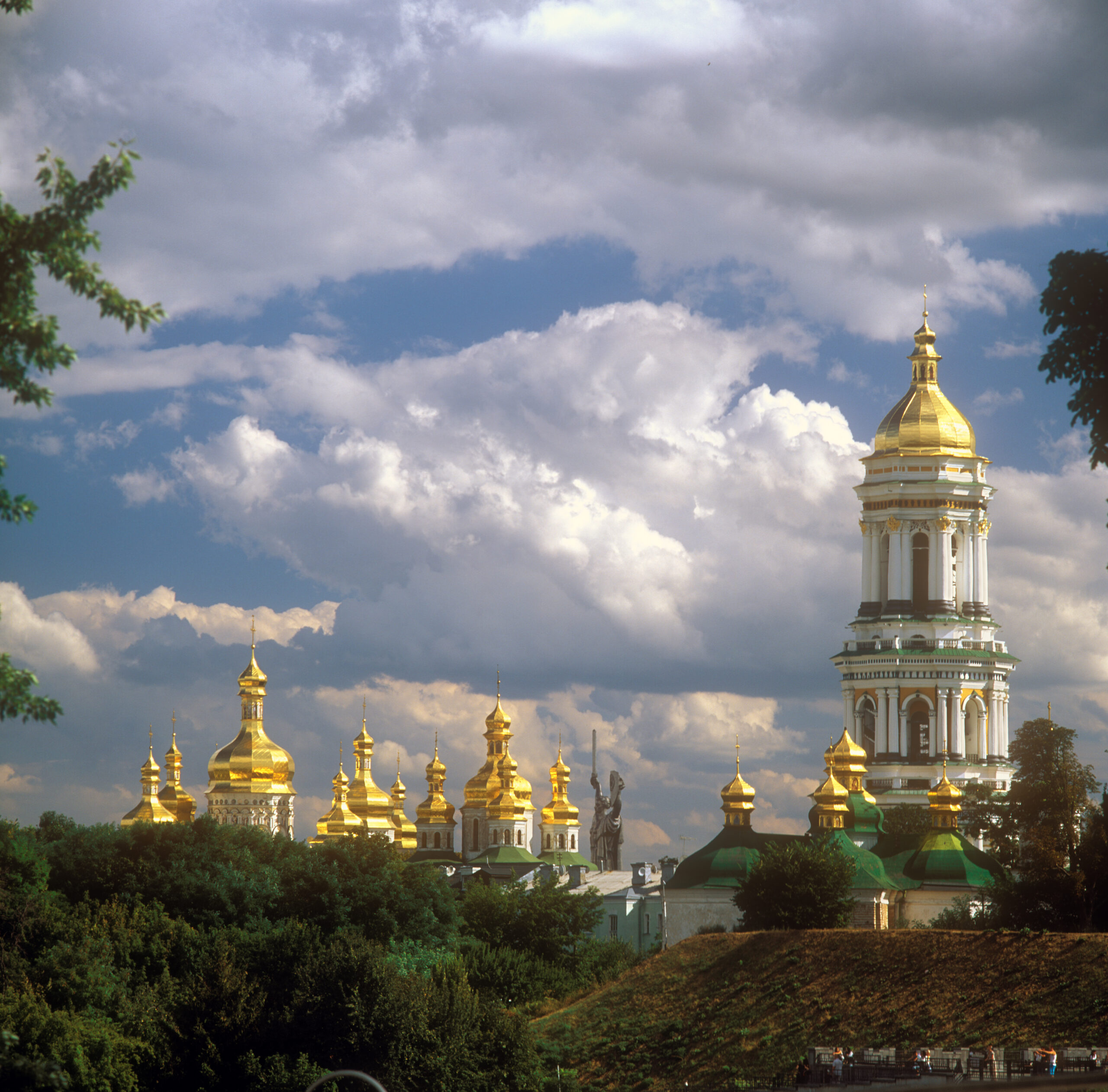 Kiovan luolaluostarin kultaiset kirkkojen kupolit piirtyvät pilvistä kesätaivasta vasten