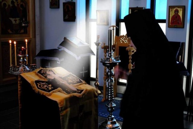 Nunna kumartaa ristiä kirkossa