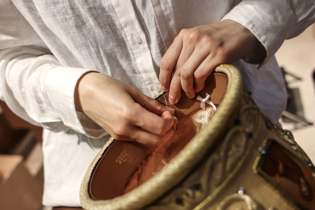 Modisti Anna-Liina Huttunen korjaamassa arkkipiispa Elian mitraa