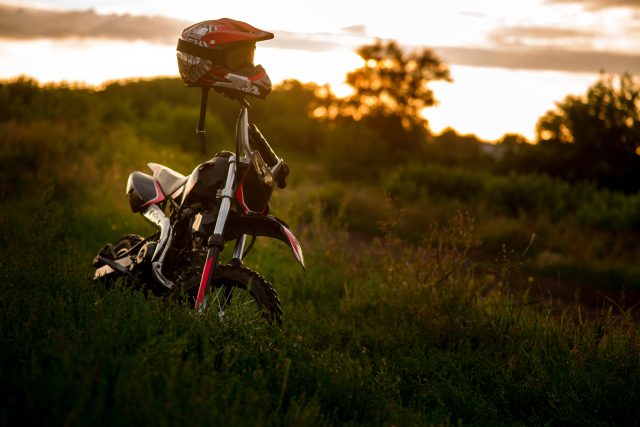 Moottoripyörä-auringonlaskun valossa lähellä järveä